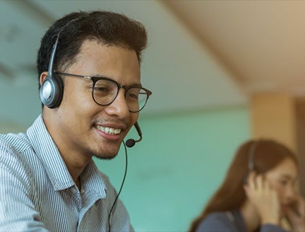 a man smiling with a headset on at work