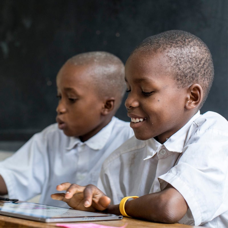 Two students in Africa learning using the winning innovation from the Global Learning XPRIZE