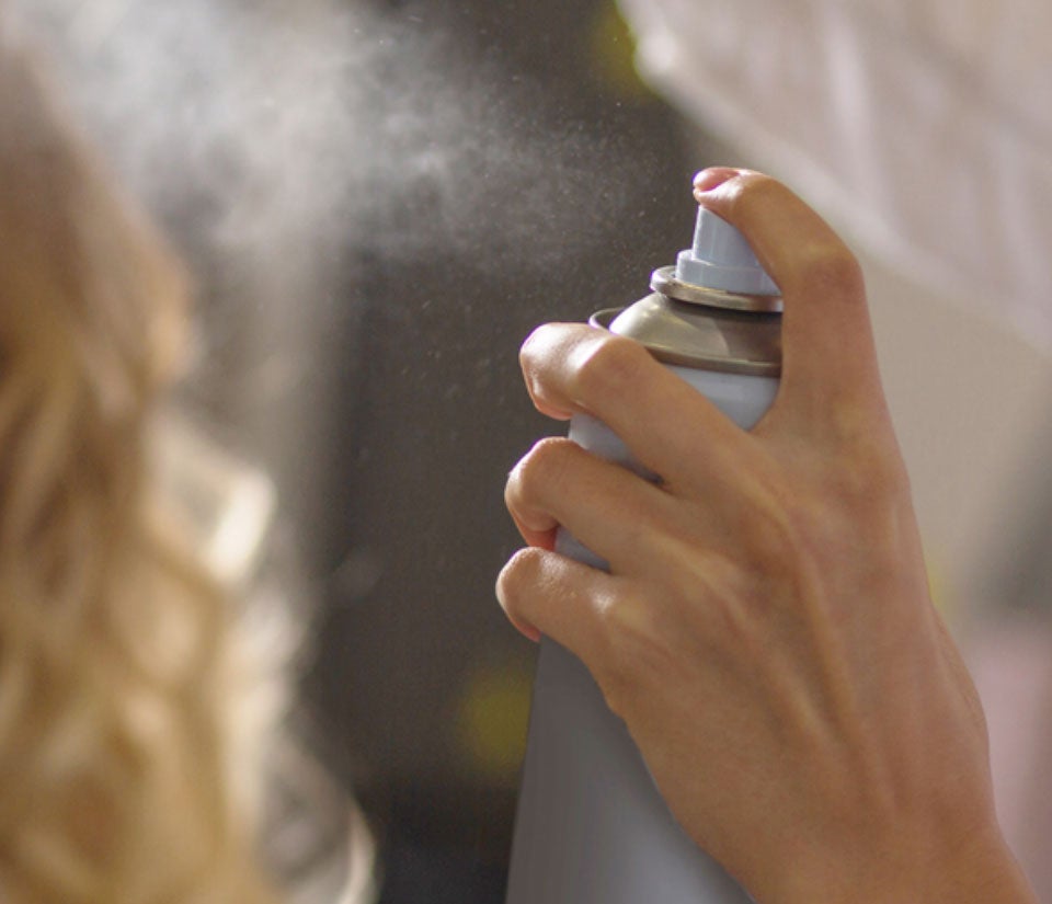 Hand spraying an aerosol can