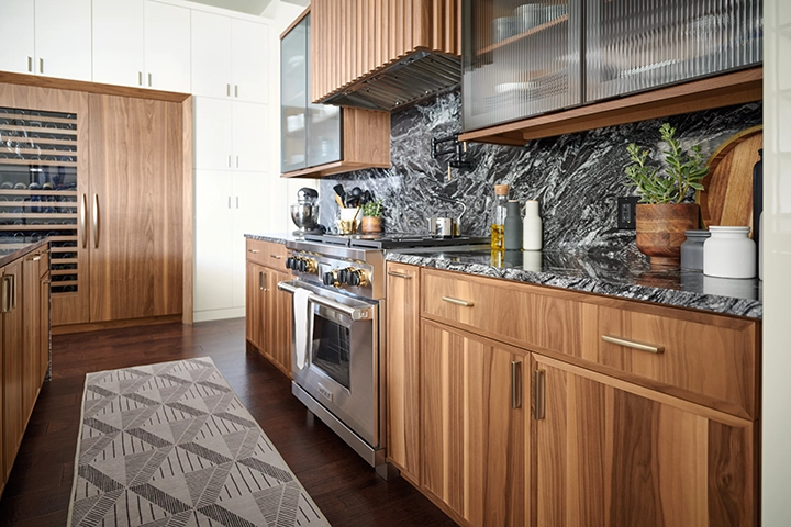 A modern-style kitchen with walnut cabinets and marble backsplash.