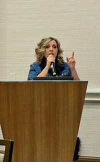 Kathy Saldana speaks at podium at conference