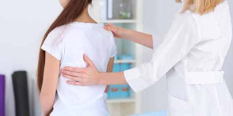 Female medical provider demonstrating to young girl proper posture.