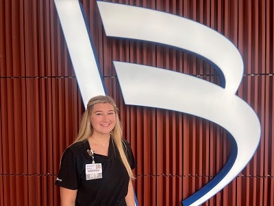 Brittany stands in front of Baptist B sign