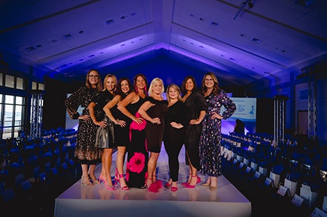 Group of women standing on runway. 