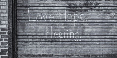 Words of love, hope and healing written on an outdoor garage door