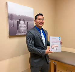 Dr. Steele holding the book he co-authored.