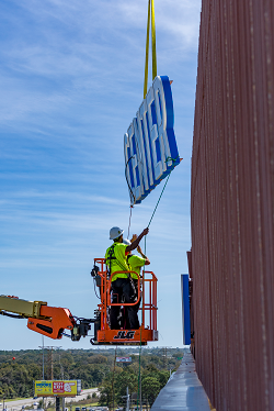 Putting up part of the sign on the Bear Family Foundation Health Center
