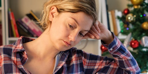 Female feeling ill and looking down during holiday season