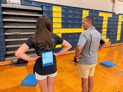 Athletic trainer showing a student how to do a balance exercise.