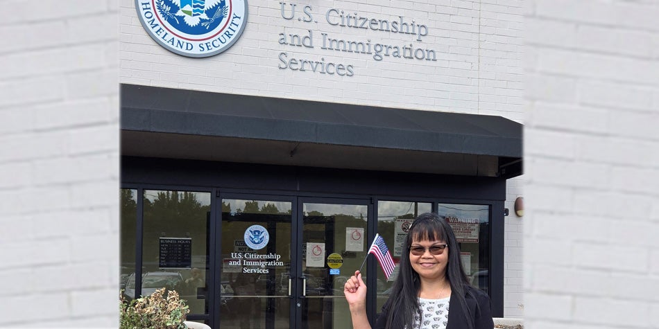 Cathy Brennan poses proudly with U.S. flag after taking oath to be official American citizen.