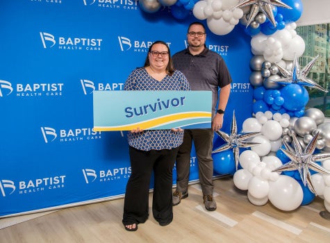 ECMO patient Brittany Herndon smiling with "survivor" sign at Baptist's ECMO Survivors Reception