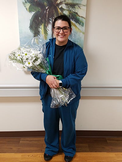 Photo of DAISY Award winner Kati Day with flower bouquet