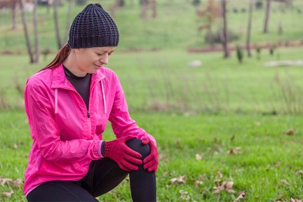 This is a female that's wearing cold-weather clothes and holding her knee, which may be in pain. 