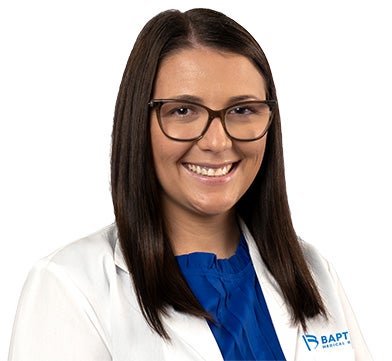 Taylor Anderson is pictured with medium brown hair, glasses, and is wearing her provider jacket.