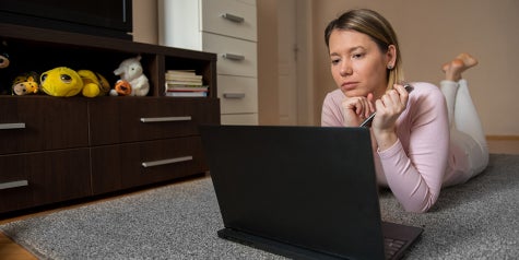Woman viewing something on her laptop in comfort of her home