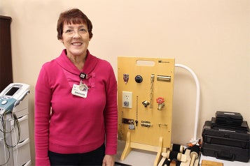 Marta Brinkley, an occupational therapist at Andrews Institute standing in front of equipment.