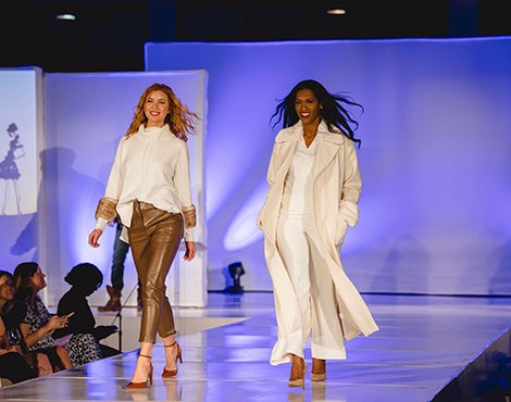 Two women walking down runway