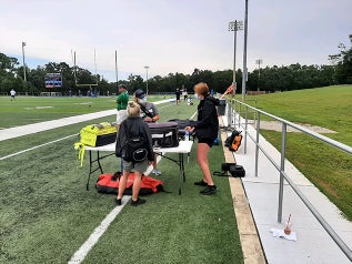 Athletic Trainers working on the sidelines of a UWF football practice.