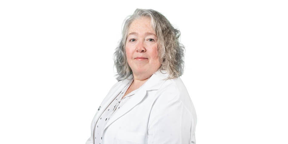 Wanda Radman, female white nurse, is smiling and wearing white doctor's coat