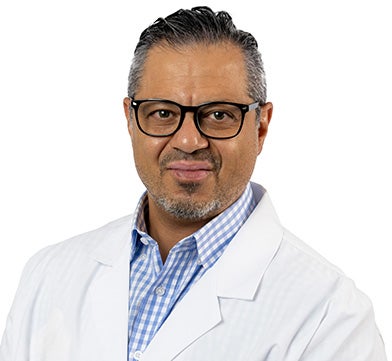 Dr. Hassan is pictured and has dark hair, glasses and is wearing a medical coat. He appears kind and confident. 