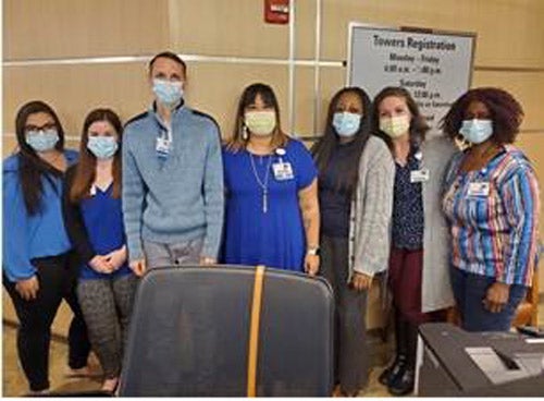 Baptist Towers outpatient registration team members (seven of them) pose and smile for the camera. 