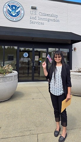 Cathy proudly stands with an American flag after becoming U.S. citizen.