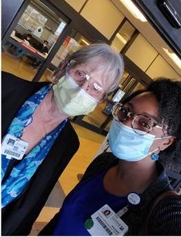 Two members of outpatient registration smile for camera. 