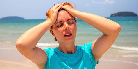 Woman looking overheated outside at the beach