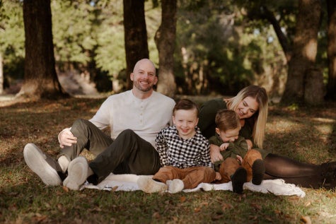 ECMO patient April with husband and two boys smiling in family photo.