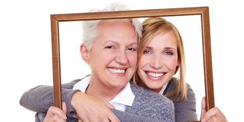 Mother and daughter looking through empty frame