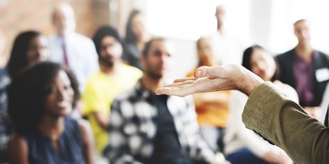 A group discussion and forum setting with people listening to one person speak