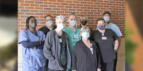 Lab department team members standing outside in a group wearing masks
