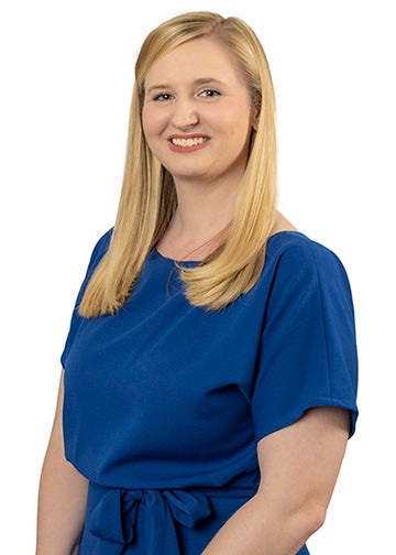 Headshot of Ashlee Hudnall with long blonde hair wearing a blue dress.
