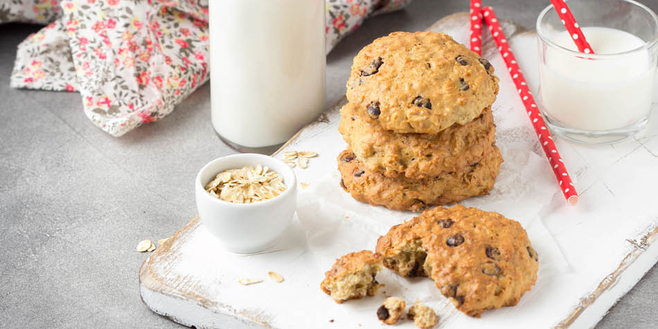 banana oatmeal chocolate chip cookies on a tray with milk