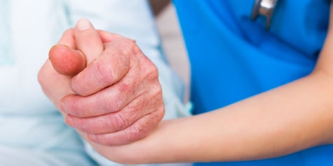 Medical provider holding patient hand.