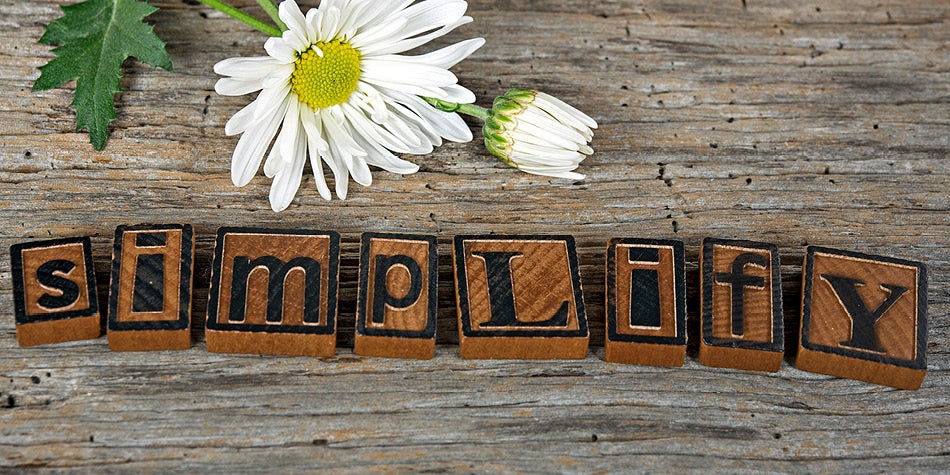 The word simplify is written in blocks with a daisy flower next to it.