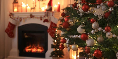 Decorated Christmas tree and fireplace with stockings hanging from it