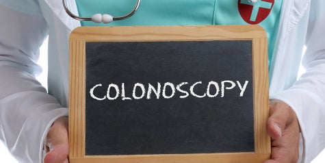 Medical professional holding up a colonoscopy sign