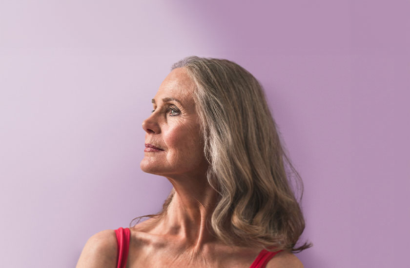 Woman looking to the left with a purple backdrop