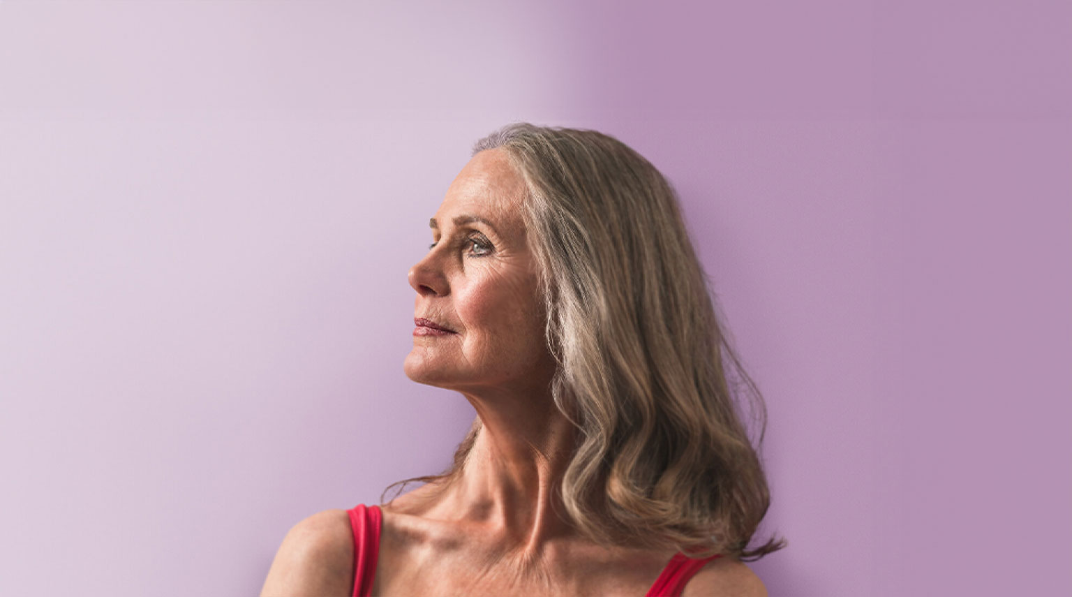 Woman looking to the left with a purple backdrop