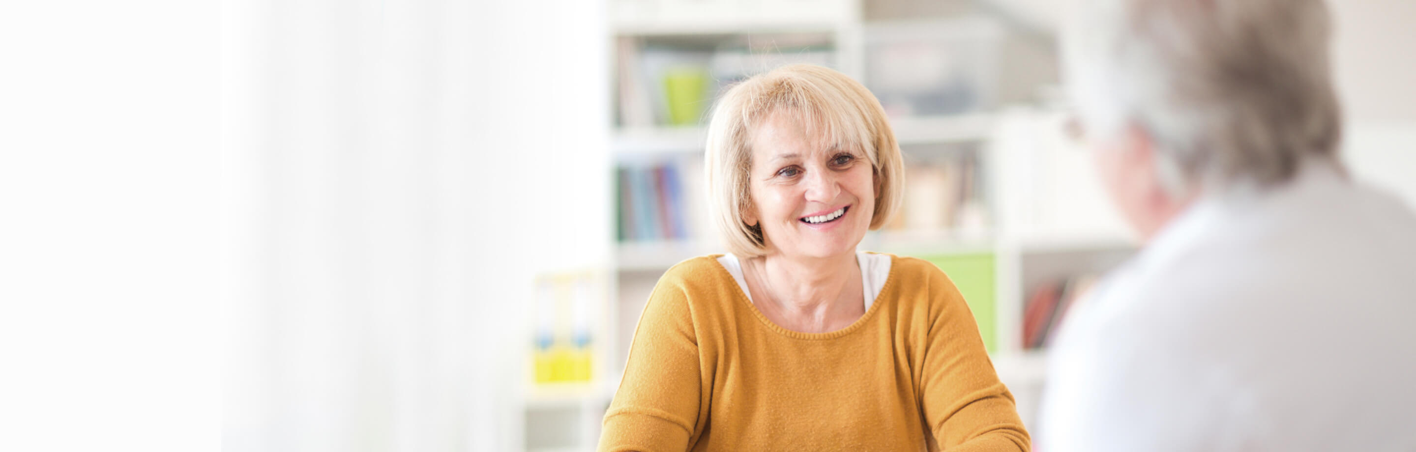 Woman wearing yellow shirt consulting with doctor