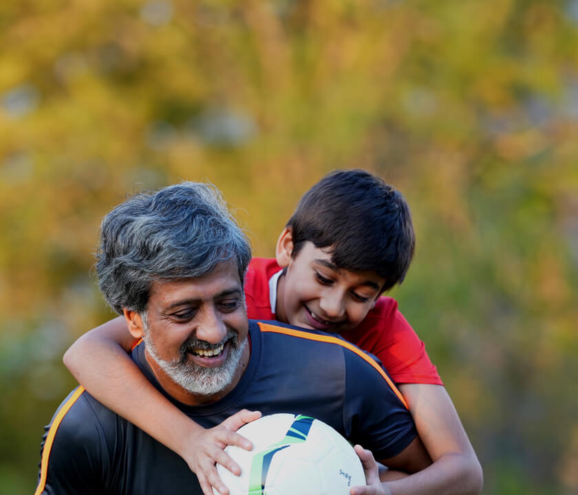 A guy with his son with football 