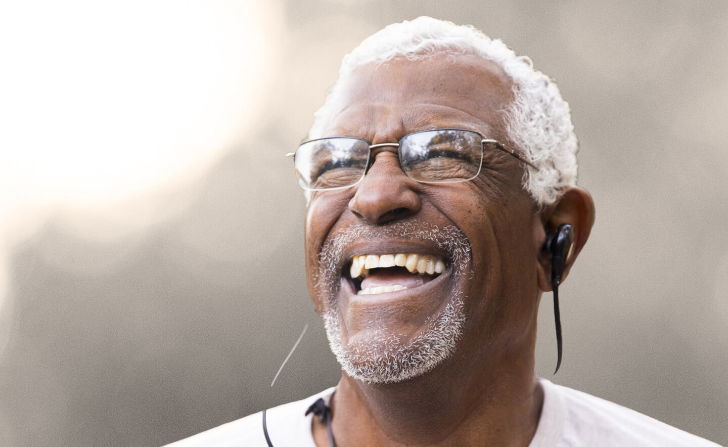 Old african man wearing glasses laughing