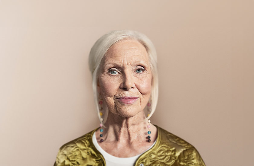 Woman standing against a tan backdrop