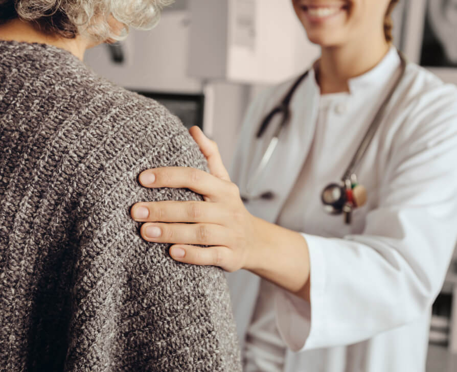 Female HCP holding woman's arm