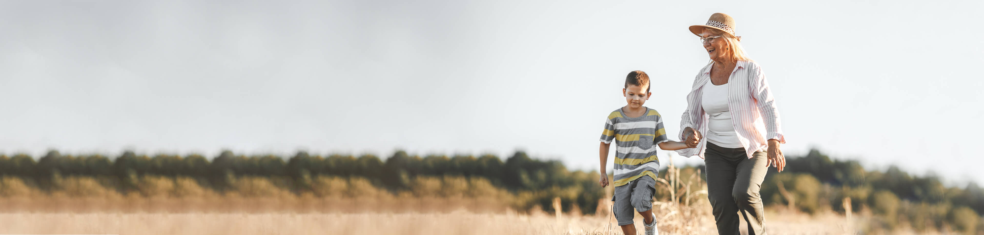 Grandma and grandson walking through field