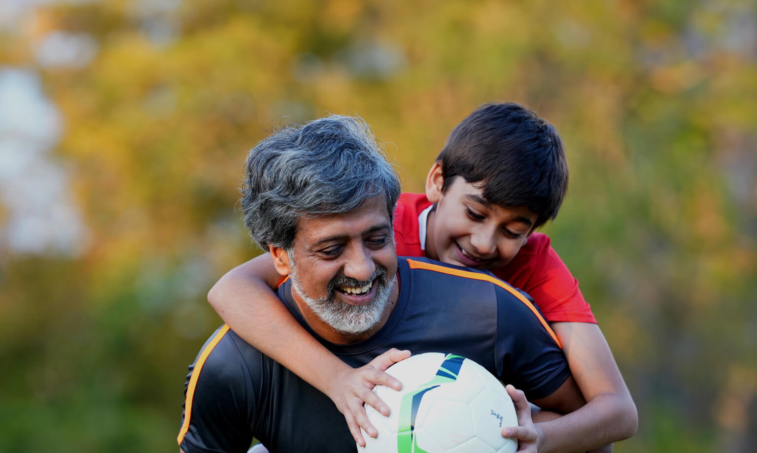 A guy playing football with his son 