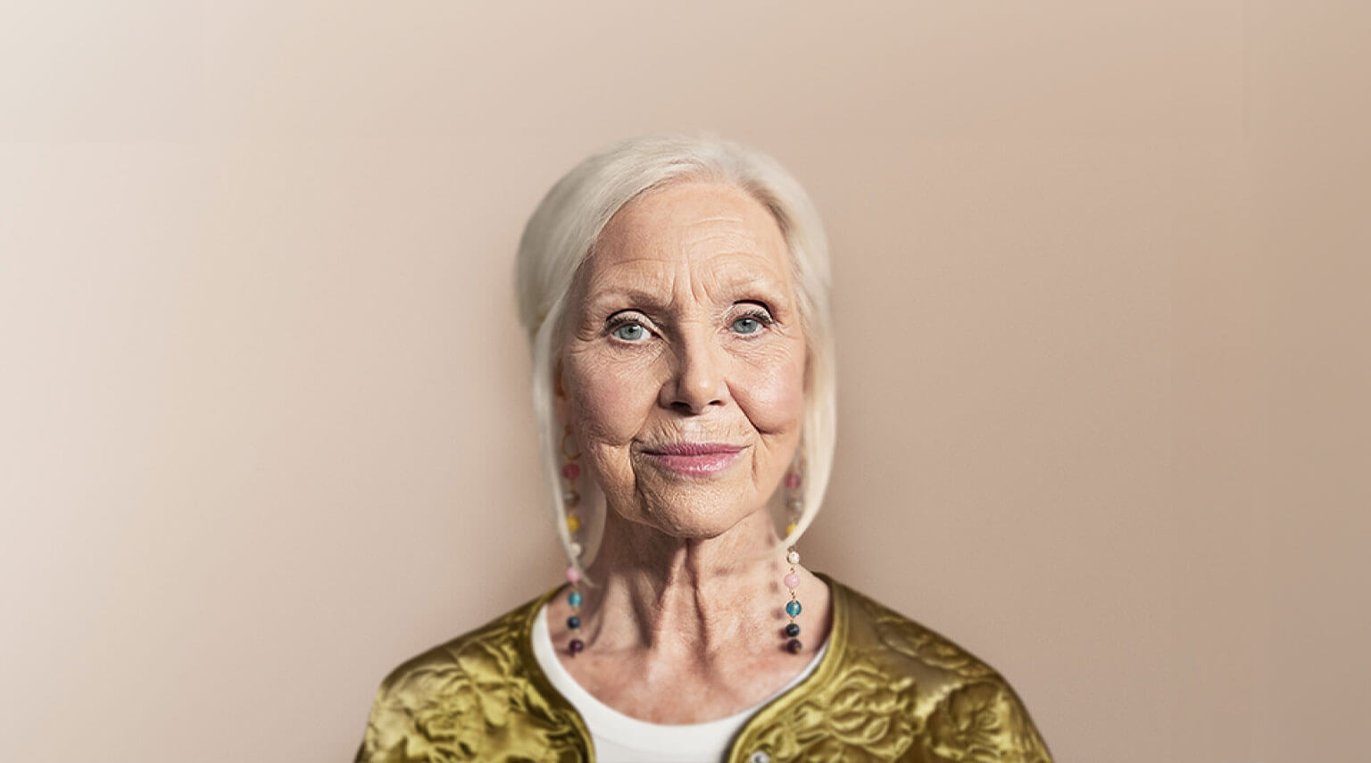 Woman standing against a tan backdrop