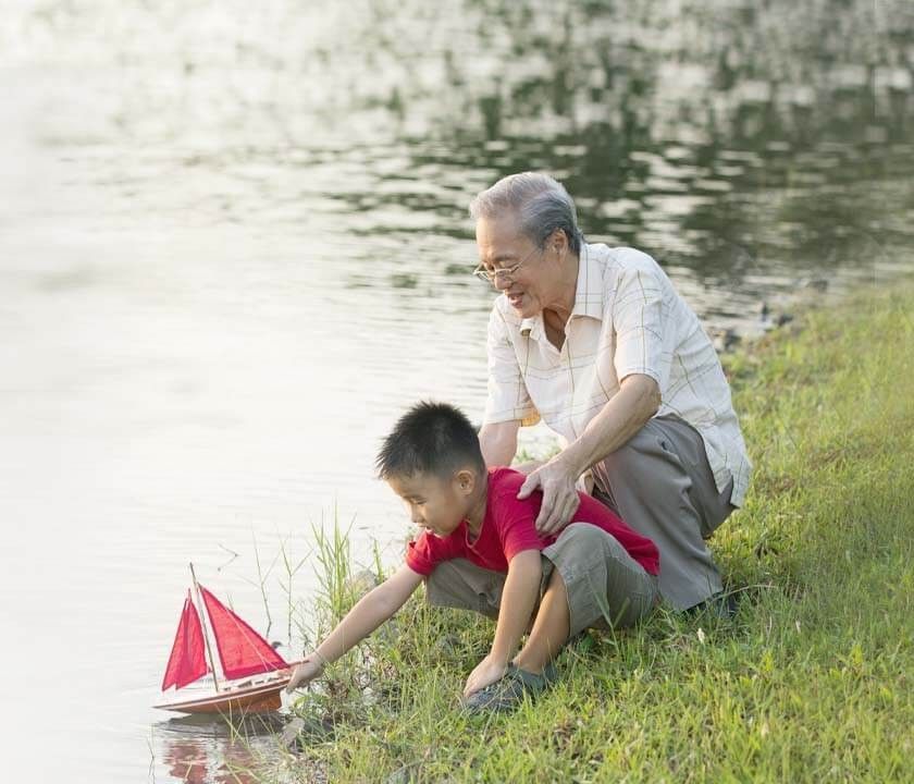 Grandpa and grandson having fun by the river