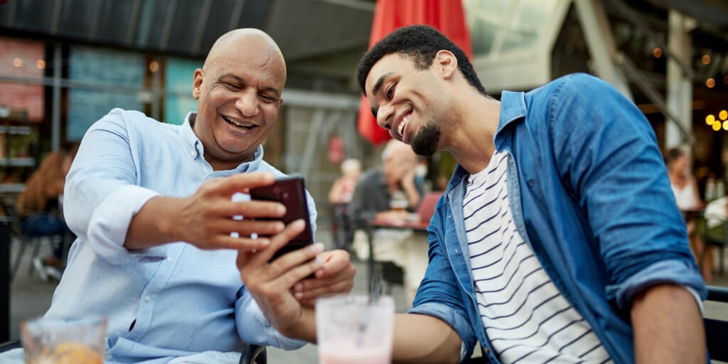 Two men looking at phone laughing